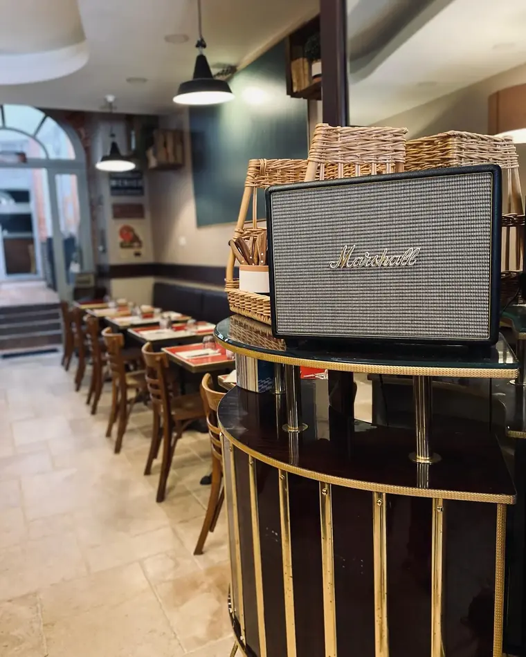 Coin salle avec enceinte Marshall et chaises bistrot